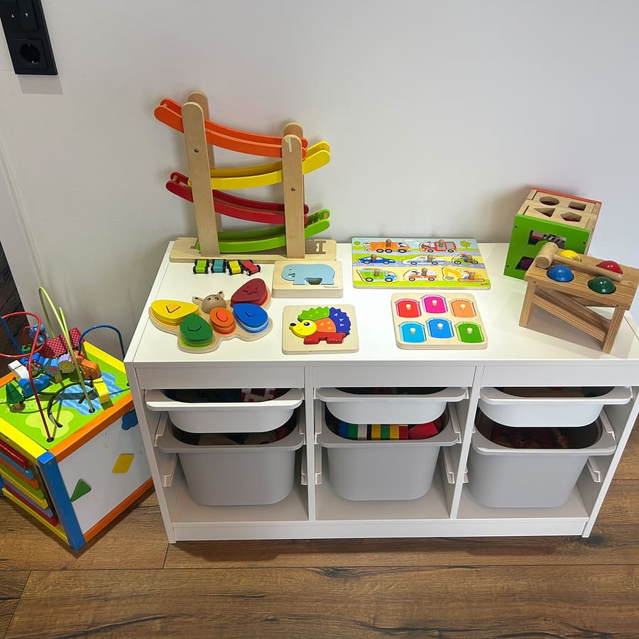 Spielregal mit Holzspielzeug, Steckpuzzles und Kugelbahn